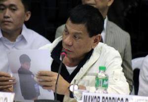 Davao Mayor Rodrigo Duterte showing photo of David Bangayan, a.k.a. David Tan, during Senate probe on rice smuggling.